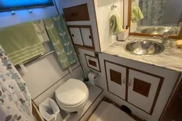Slide: The Image of 1982 C @ L Sea Ranger bathroom with sink, toilet, and storage cabinets. - 54