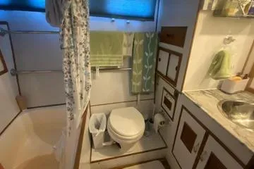 Slide: The Image of 1982 C @ L Sea Ranger bathroom with shower, toilet, and sink, featuring green and floral accents. - 55