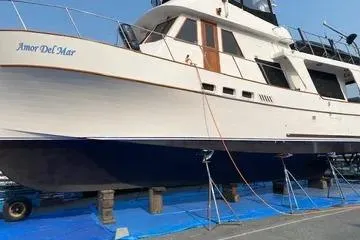 Slide: The Image of 1982 C @ L Sea Ranger yacht on stands, named "Amor Del Mar," with blue tarp underneath. - 6