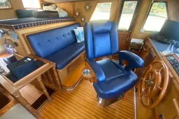 Slide: The Image of Interior of 1982 C @ L Sea Ranger yacht with blue seating and wooden helm. - 70