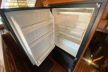 Slide: The Image of Open refrigerator inside 1982 C @ L Sea Ranger yacht, showcasing interior shelves. - 75