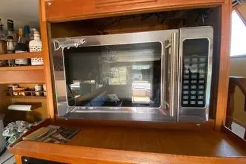 Slide: The Image of 1982 C @ L Sea Ranger interior with built-in microwave and wooden cabinetry. - 76
