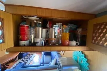 Slide: The Image of Kitchen storage area inside a 1982 C @ L Sea Ranger boat, featuring various kitchenware. - 77