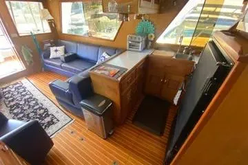 Slide: The Image of 1982 C @ L Sea Ranger interior with cozy seating, kitchenette, and wooden flooring. - 80