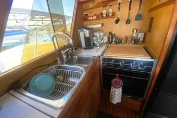Slide: The Image of Compact kitchen in 1982 C @ L Sea Ranger boat with sink, stove, and utensils. - 83