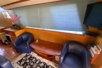 Slide: The Image of 1982 C @ L Sea Ranger interior with blue chairs, wooden table, and floral decor. - 86