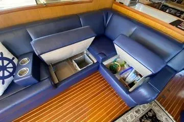 Slide: The Image of 1982 C @ L Sea Ranger interior with blue seating, storage compartments, and nautical decor. - 88