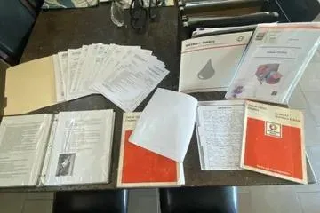 Slide: The Image of Assorted documents and manuals for a 1982 C @ L Sea Ranger Sea Ranger, spread on a table. - 93