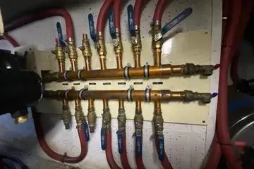 Slide: The Image of 1982 C @ L Sea Ranger plumbing system with copper pipes and red hoses. - 99