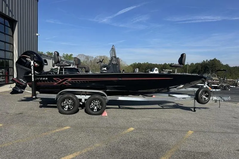The Image of 2026 Xpress H22B Bay boat on trailer, parked outdoors under clear sky. - 0