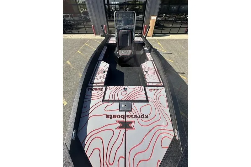 Slide: The Image of 2026 Xpress H22B Bay boat with modern design and red contour graphics. - 2