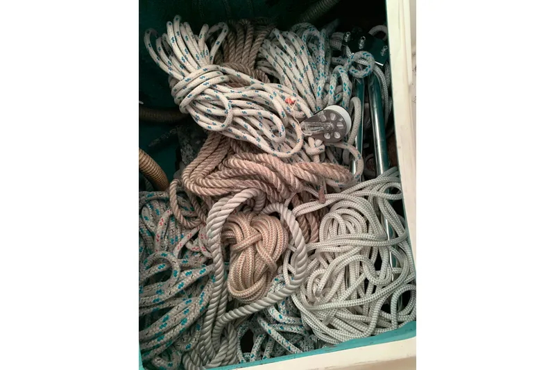 Slide: The Image of Coiled ropes and pulleys in a 1984 Sabre 38 sailboat storage compartment. - 21