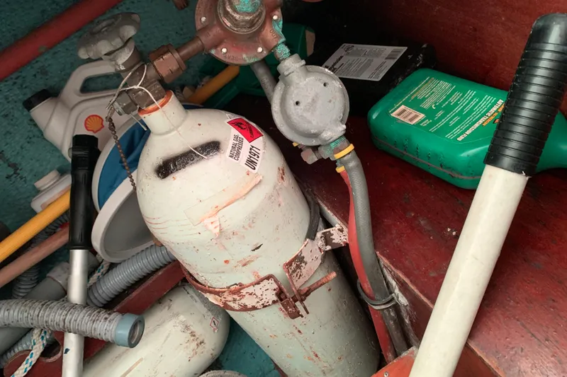 Slide: The Image of Storage area with propane tank, hoses, and cleaning supplies on a 1984 Sabre 38 boat. - 27