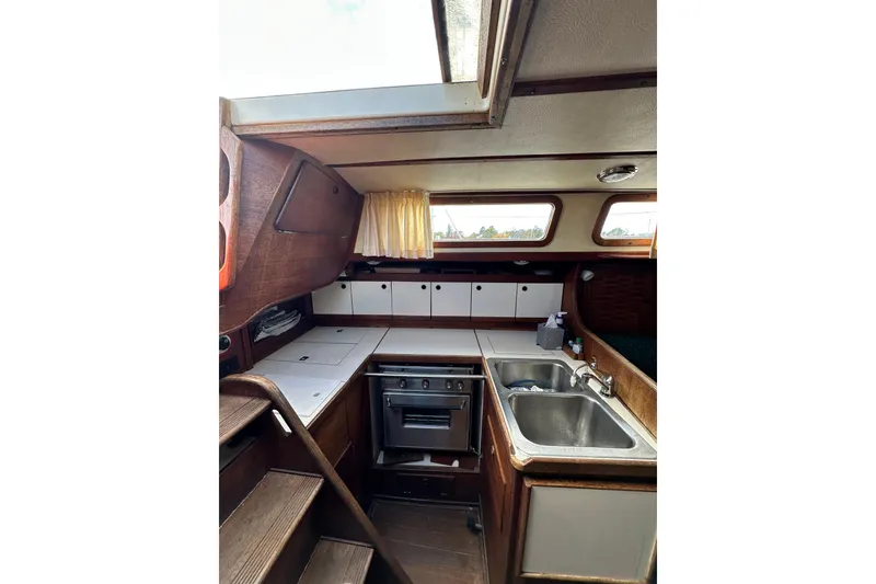 Slide: The Image of Interior of 1984 Sabre 38 sailboat galley with stove, sink, and wooden cabinetry. - 39