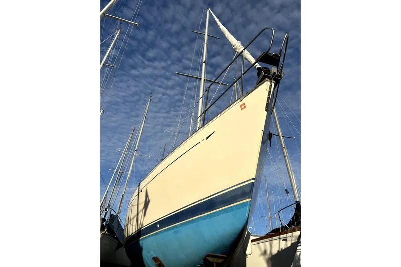 Slide: The Image of 1984 Sabre 38 sailboat with blue hull, docked under a clear sky. - 4