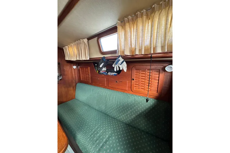 Slide: The Image of Interior of 1984 Sabre 38 sailboat with green cushioned seating and wooden cabinetry. - 45