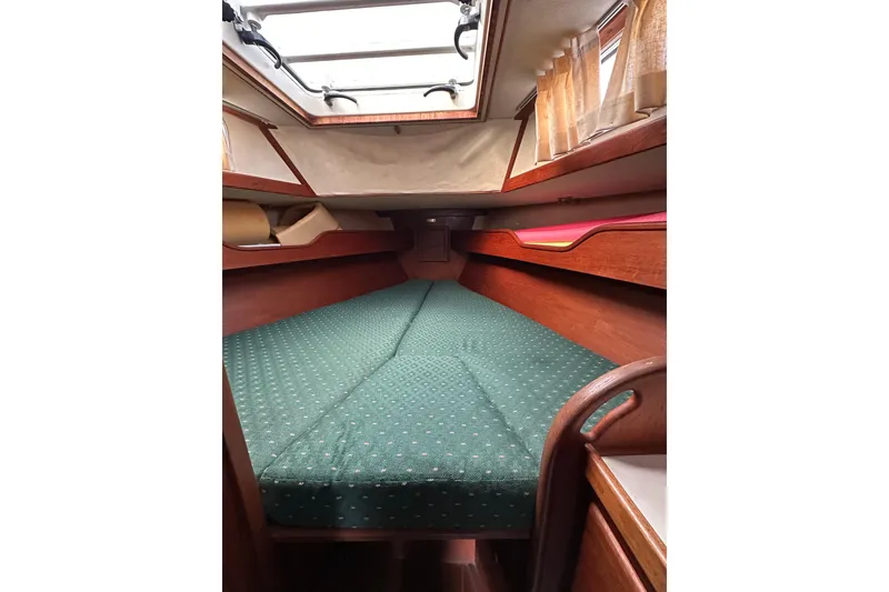 Slide: The Image of Cozy cabin interior of 1984 Sabre 38 sailboat with green cushioned berth. - 46