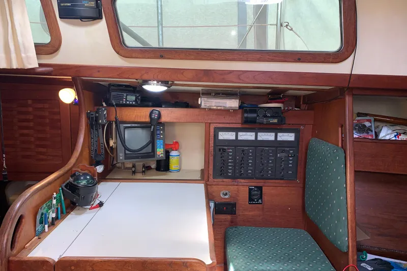 Slide: The Image of Navigation station inside a 1984 Sabre 38 sailboat with control panels and equipment. - 50