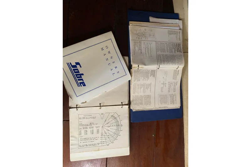 Slide: The Image of 1984 Sabre 38 owner's manual with technical diagrams and instructions on a wooden surface. - 51