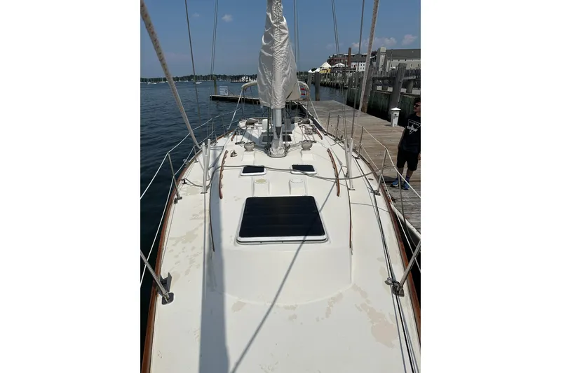 Slide: The Image of 1984 Sabre 38 sailboat docked, showcasing deck and rigging under clear skies. - 64