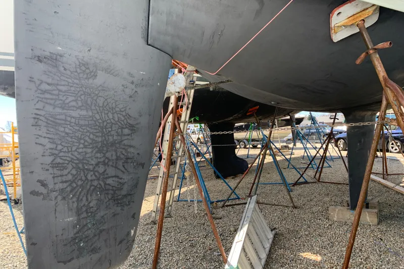 Slide: The Image of 1984 Sabre 38 sailboat keel and hull on stands, showing wear and maintenance setup. - 7