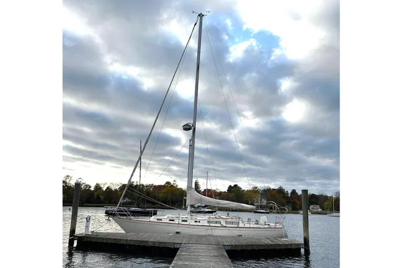 The Image of 1984 Sabre 38 sailboat docked under cloudy sky at a serene marina. - 0