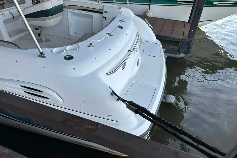 Slide: The Image of 1998 Chaparral Sunesta 252 boat docked, showing rear deck and seating area. - 11