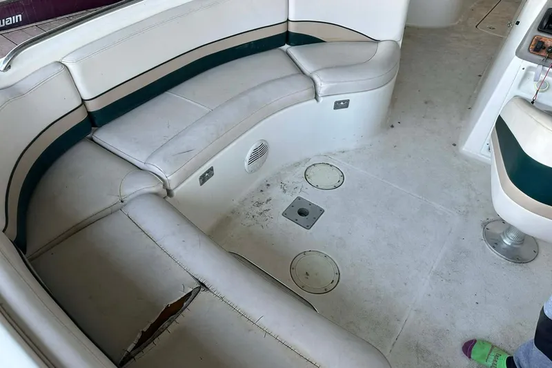 Slide: The Image of Interior of a 1998 Chaparral Sunesta 252 boat with worn seating and carpet. - 12