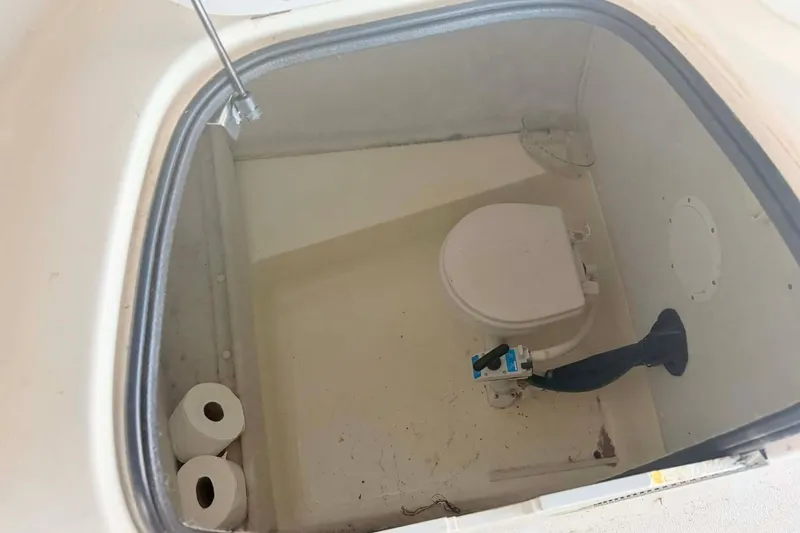 Slide: The Image of 1998 Chaparral Sunesta 252 boat toilet compartment with toilet paper rolls. - 13