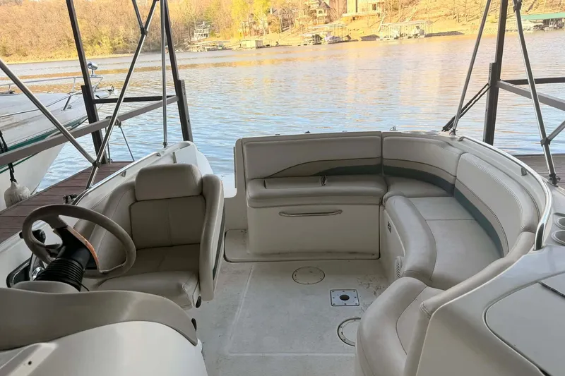 Slide: The Image of 1998 Chaparral Sunesta 252 boat interior with seating and steering wheel by the water. - 16