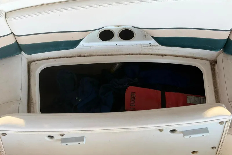 Slide: The Image of Storage compartment on a 1998 Chaparral Sunesta 252 boat, containing life jackets. - 19