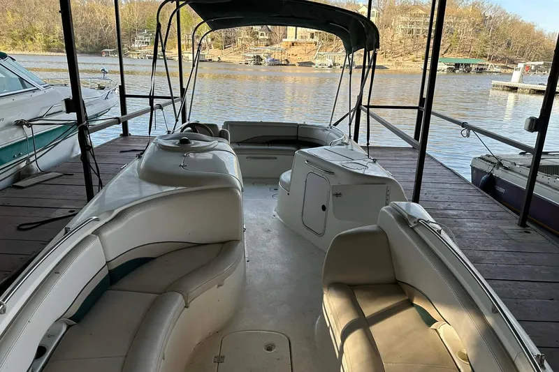 Slide: The Image of 1998 Chaparral Sunesta 252 boat docked, featuring spacious seating and canopy. - 21
