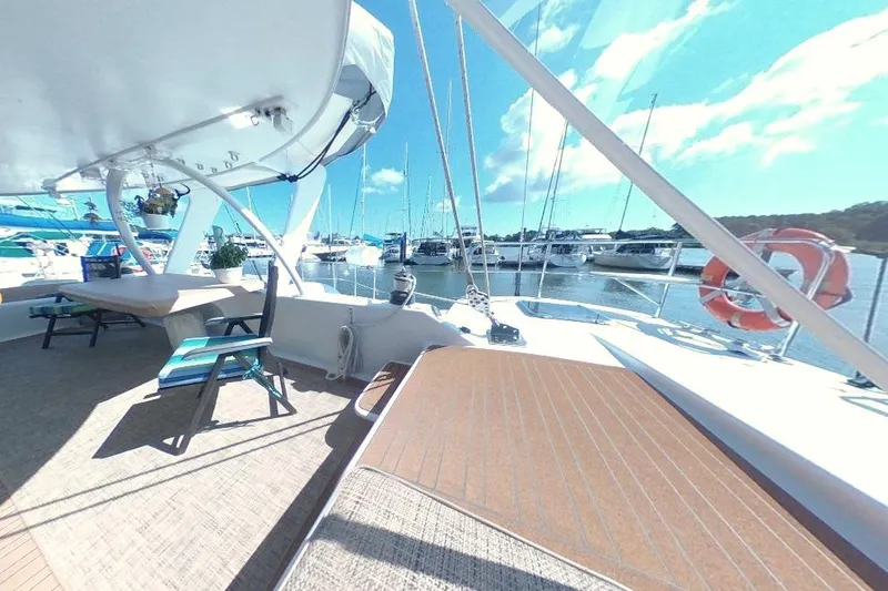 Slide: The Image of Spacious deck of 1988 Kelsall Manannan Custom yacht, docked at marina under clear blue sky. - 11