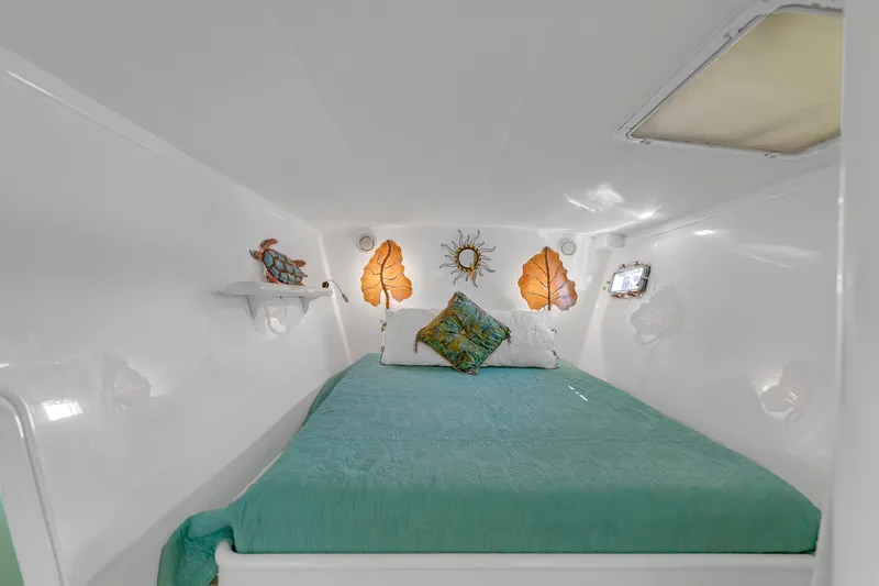 Slide: The Image of Cozy cabin interior of 1988 Kelsall Manannan Custom boat with teal bedding and decorative accents. - 19