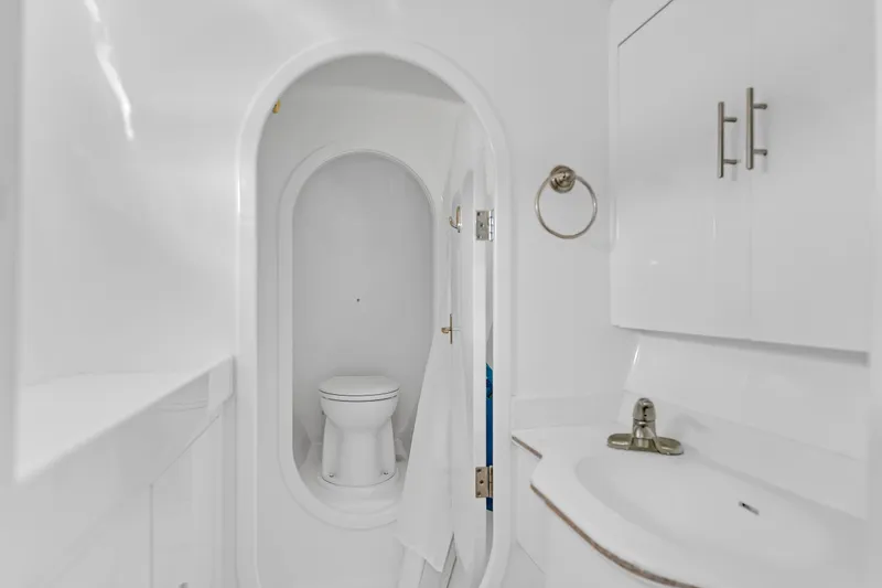 Slide: The Image of White bathroom interior on 1988 Kelsall Manannan Custom boat, featuring toilet and sink. - 35