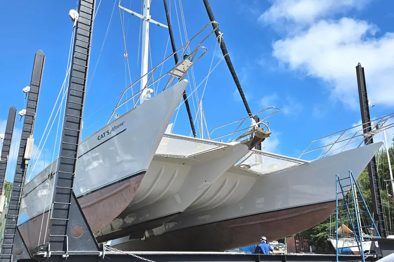 Slide: The Image of Kelsall Manannan 78 Custom catamaran from 1988 in dry dock under clear blue sky. - 59