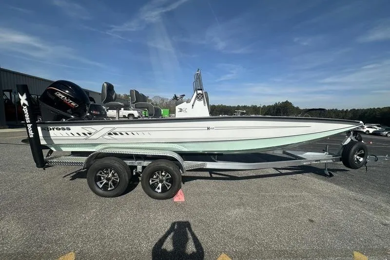 Slide: The Image of 2026 Xpress H22B Bay boat on trailer, parked outdoors under clear sky. - 10