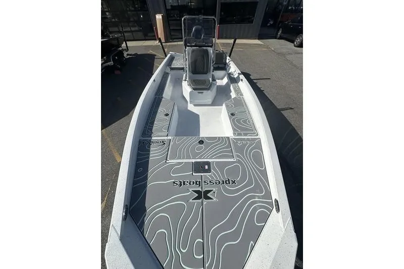 Slide: The Image of 2026 Xpress H22B Bay boat with custom deck design in a showroom. - 2