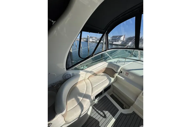 Slide: The Image of Interior view of 2005 Sea Ray Sundancer 260 boat with seating and waterfront backdrop. - 10