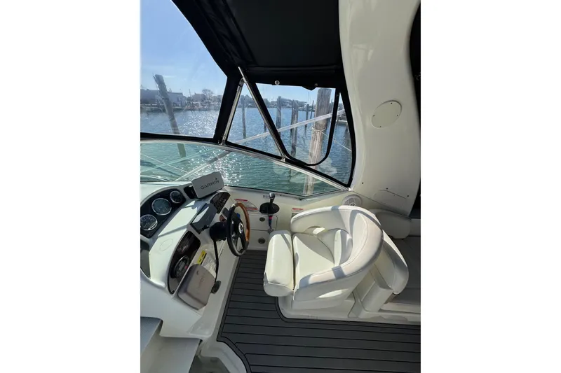 Slide: The Image of 2005 Sea Ray Sundancer 260 helm with Garmin navigation, docked by the water. - 11