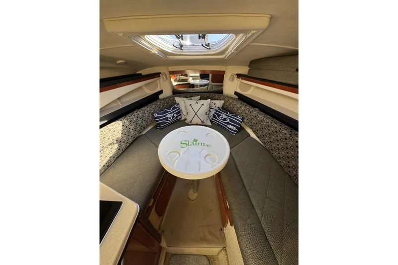 Slide: The Image of Interior of 2005 Sea Ray Sundancer 260 with cozy seating and decorative pillows. - 14