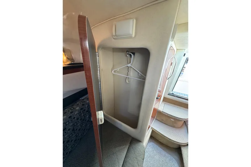 Slide: The Image of Interior closet of 2005 Sea Ray Sundancer 260 boat with open door and hangers. - 22
