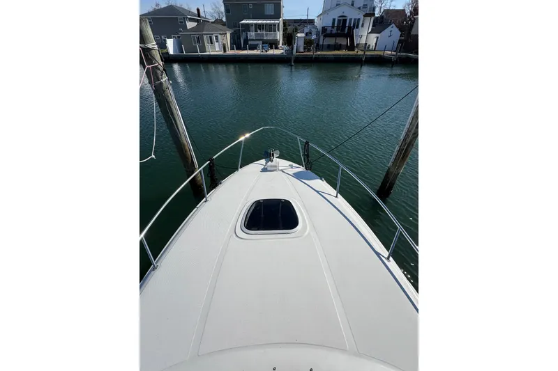 Slide: The Image of Bow view of 2005 Sea Ray Sundancer 260 docked in a serene marina. - 27