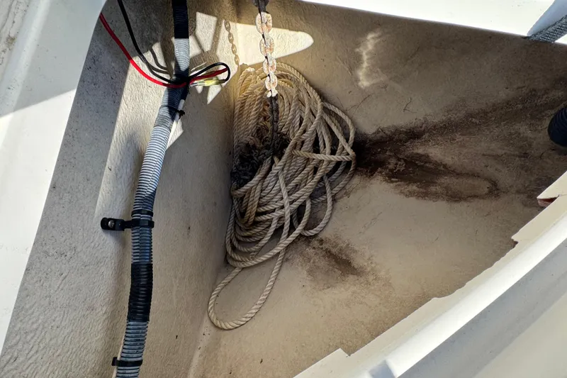 Slide: The Image of Anchor locker of a 2005 Sea Ray Sundancer 260 with coiled rope and wiring. - 29