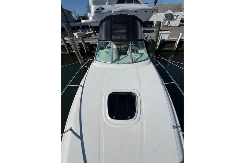 Slide: The Image of 2005 Sea Ray Sundancer 260 boat docked, showcasing sleek design and spacious deck. - 30
