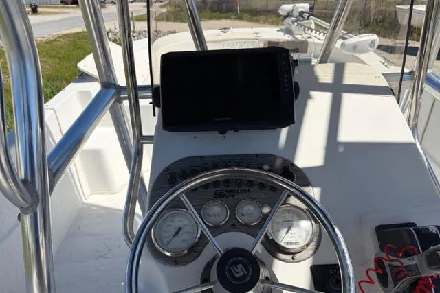 Slide: The Image of 2014 Carolina Skiff 218 DLV boat dashboard with steering wheel and navigation equipment. - 4