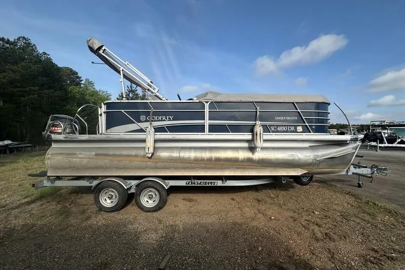 The Image of 2021 Godfrey Sweetwater 2186 C pontoon boat on trailer, parked outdoors. - 0