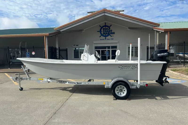 The Image of 2026 Coastal Skiff 184 boat on trailer outside Gulf Coast Marine building. - 0