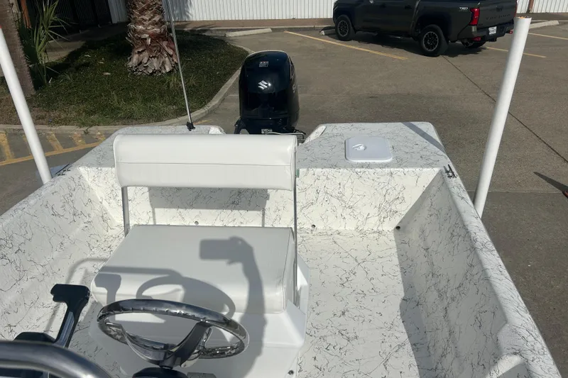 Slide: The Image of 2026 Coastal Skiff 184 boat interior with white seating and steering wheel. - 12