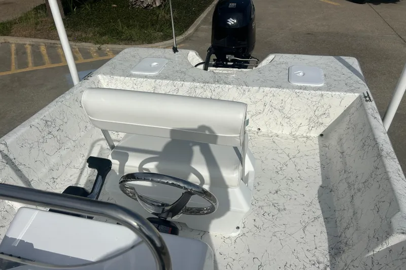 Slide: The Image of 2026 Coastal Skiff 184 boat interior with steering wheel and outboard motor. - 13